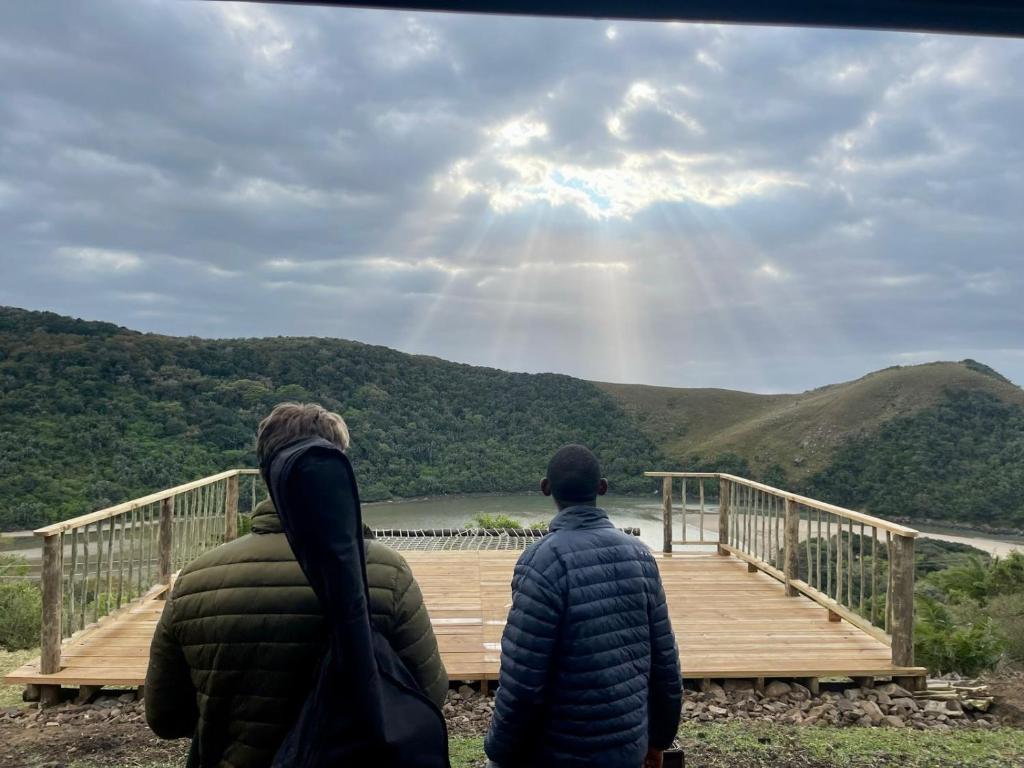 zwei Menschen stehen auf einer Brücke über einen See in der Unterkunft Mantekuview Homestay 