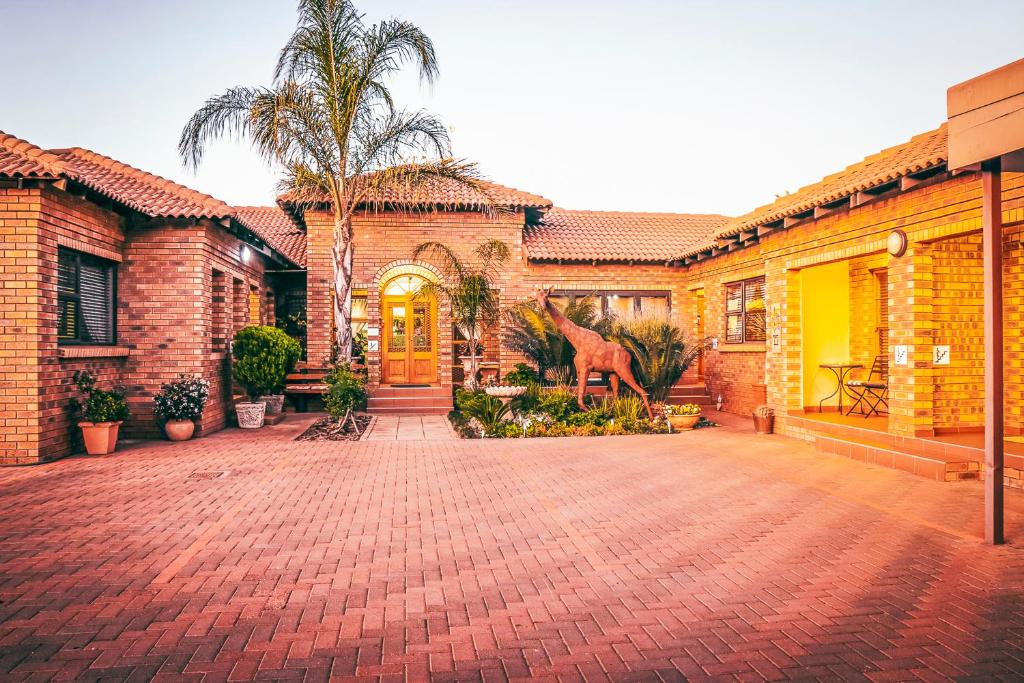 a brick house with a brick driveway in front of it at Villa Mosaiko in Kathu