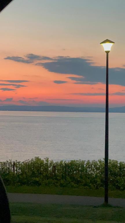 a street light in front of the ocean at sunset at Garden Place in Clevedon