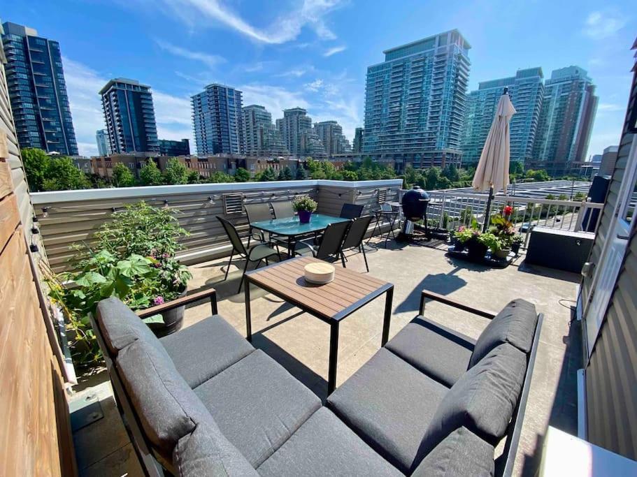 a patio with a table and chairs on a balcony at King West Private Rooftop Retreat in Toronto