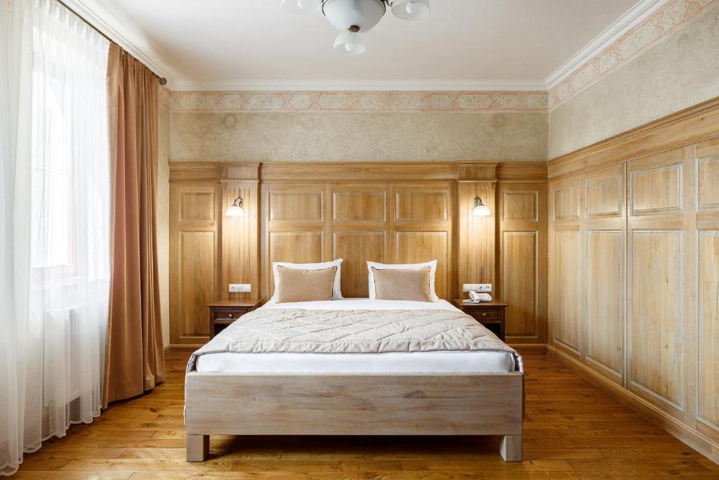 a bedroom with a large bed with wood paneling at GANZ HOTEL in Ivano-Frankivsʼk