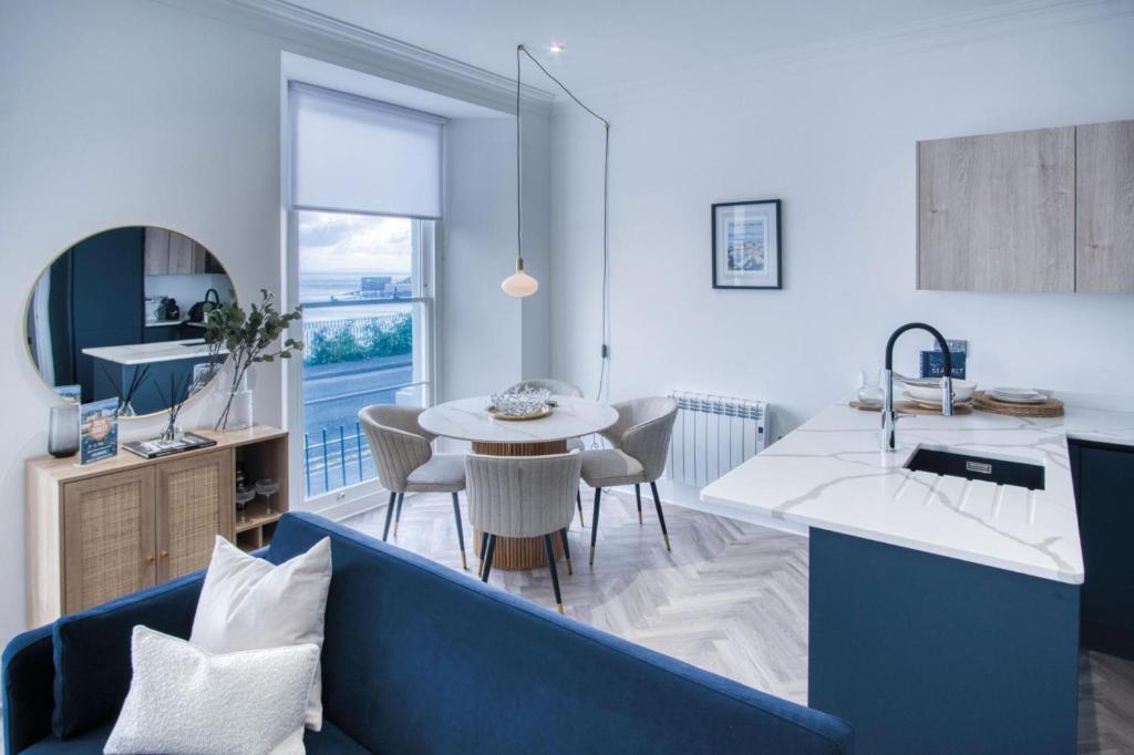 uma sala de estar com um sofá azul e uma mesa em No 4 Croft House - Luxury 2 Bed Apartment - Tenby em Tenby