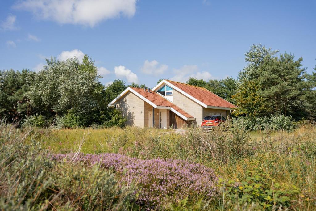 a house in the middle of a field at Vakantiepark Klein Vaarwater in Buren