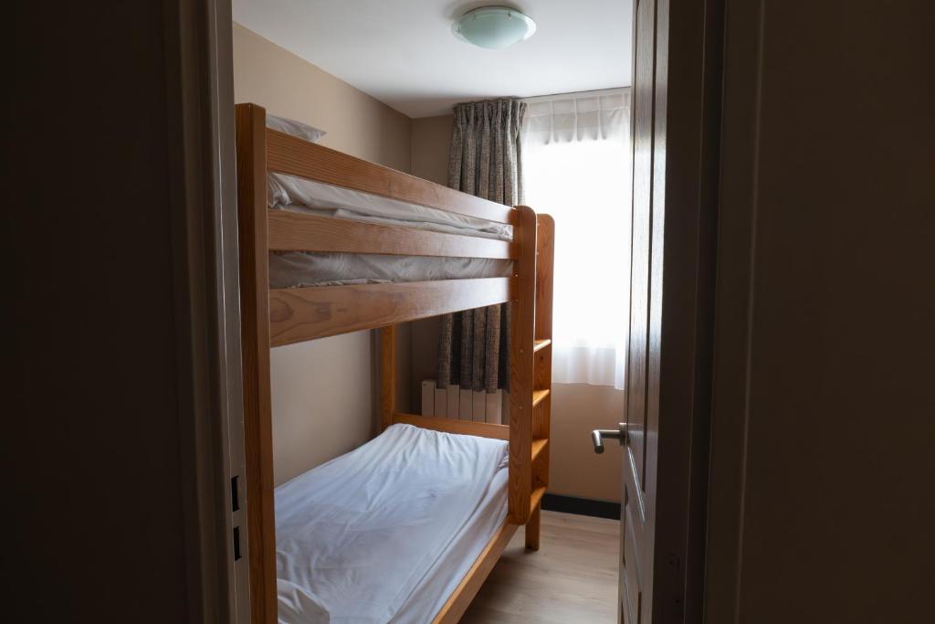 a bedroom with two bunk beds in a room at Hôtel Les Arches in Saint-Lary-Soulan