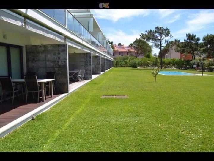 a large yard of grass next to a building at Casas Da Duna in Troia