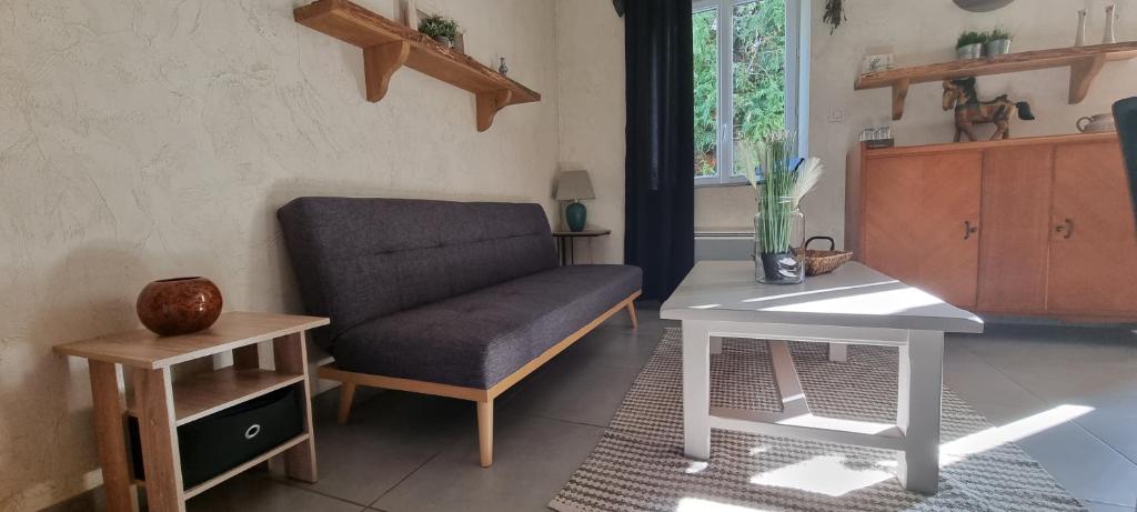 a living room with a chair and a table at Meublé de tourisme &quot;Les brosses tillots&quot; in Mary