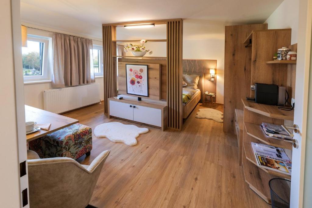 a living room with a bed and a mirror at Appartements am Landschaweg in Weiz