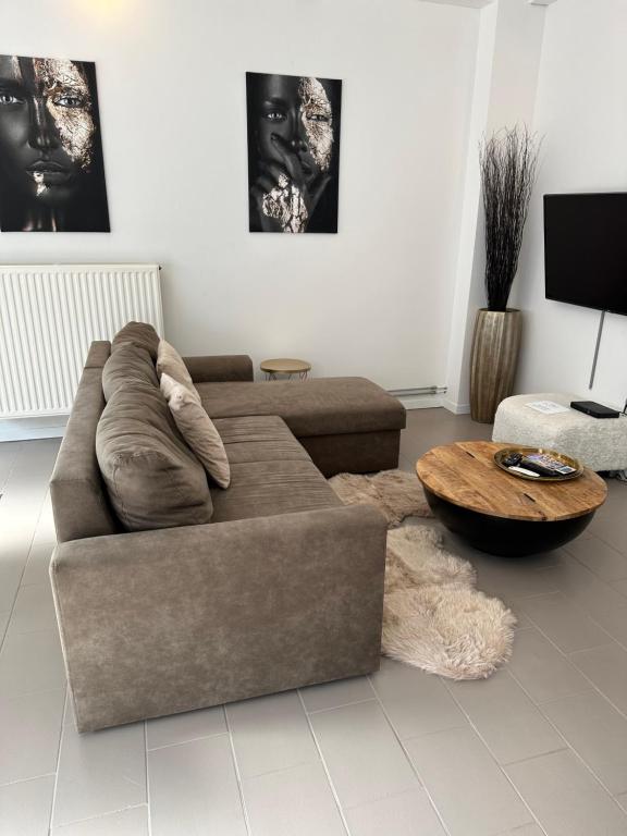 Una sala de estar con un sofá y una mesa de café. en Antwerp West Side, en Zwijndrecht
