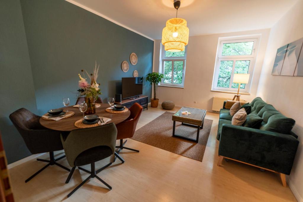 uma sala de estar com uma mesa e um sofá verde em RR - Comfortable Apartment 60 qm - Central - WIFI em Magdeburg