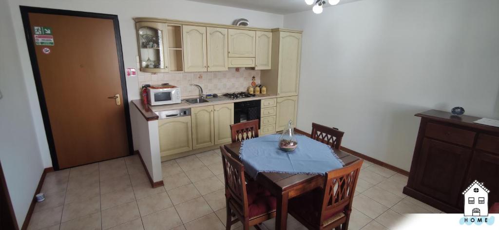 een keuken met een tafel en stoelen en een koelkast bij Appartamento in centro HOME in Monfalcone