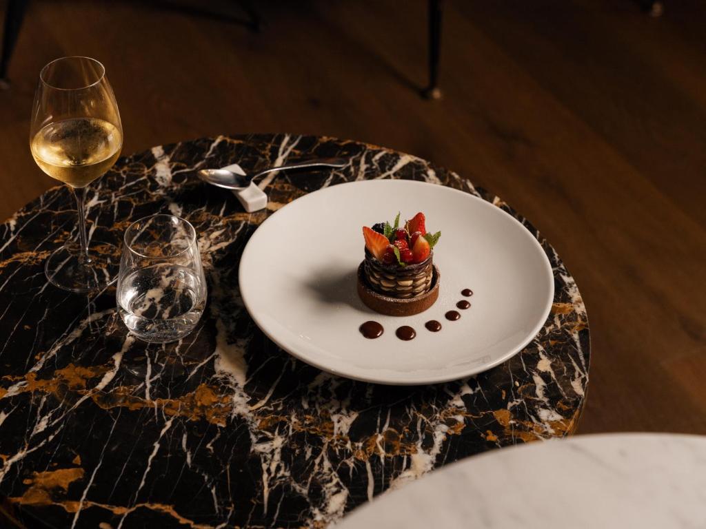 a plate with a bowl of fruit on a table at Re Versiliana Hotel in Marina di Pietrasanta