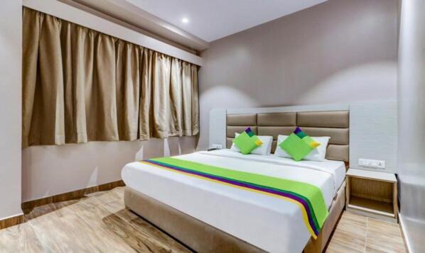 um quarto com uma cama grande e um cobertor colorido em SO-HOTEL em Howrah