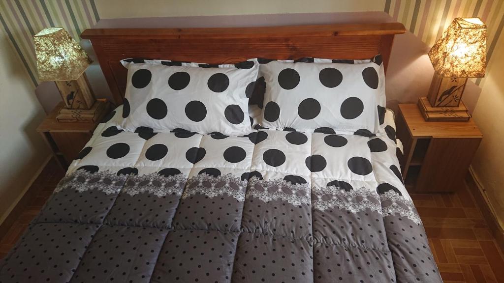 een bed met zwarte en witte lakens en kussens bij Residential Superb Rooms, With Wifi, Netflix, Parking, Kitchen in Kampala