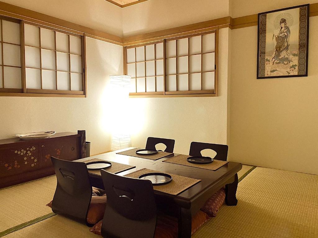 Tatami house Skytree view Asakusa line في طوكيو: طاولة طعام وكراسي في الغرفة