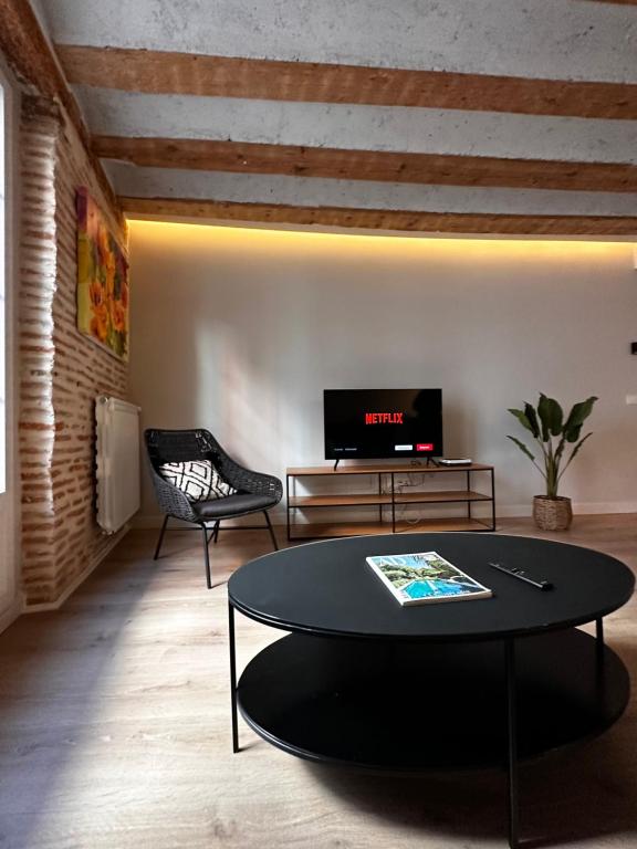 a living room with a table and a tv at El Mirador De La Puebla Vut ATUAIRE Parking Incluido in Burgos