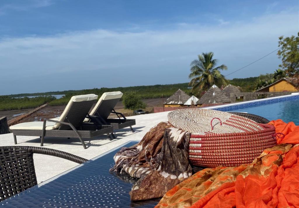 a wicker basket sitting on a table next to a pool at Toubacouta Lodges in Toubakouta