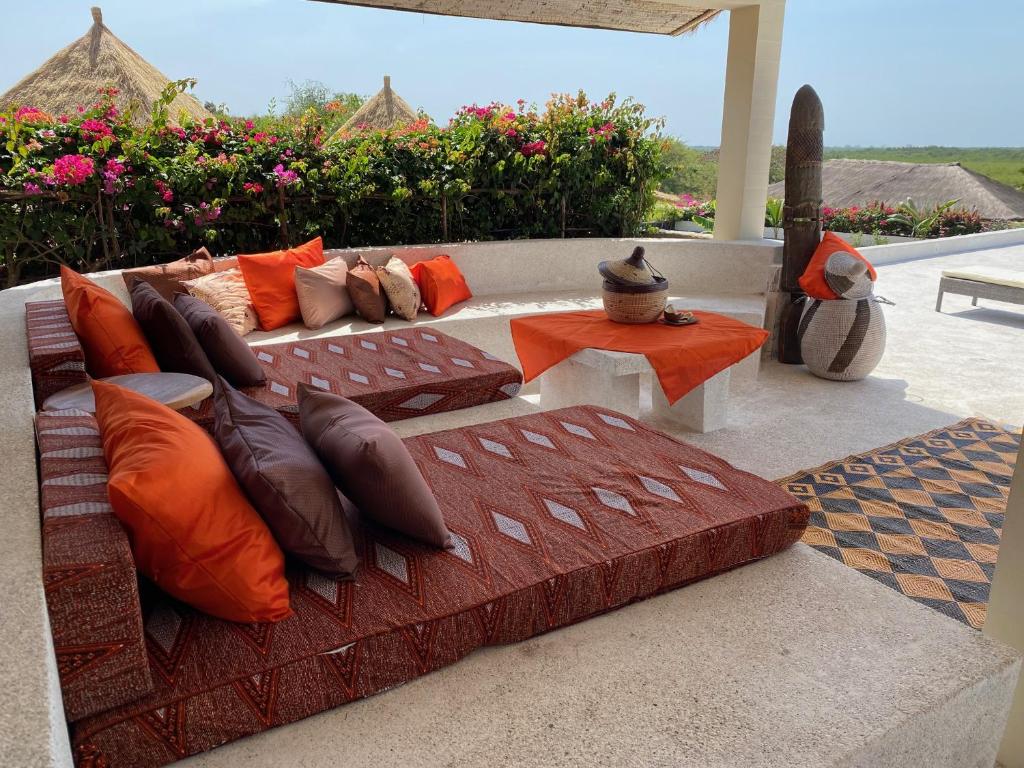 a couch with pillows sitting on a patio at Toubacouta Lodges in Toubakouta