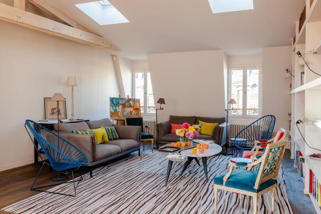 un salon avec un canapé, une table et des chaises dans l'établissement Veeve - Soulful Fusion, à Paris