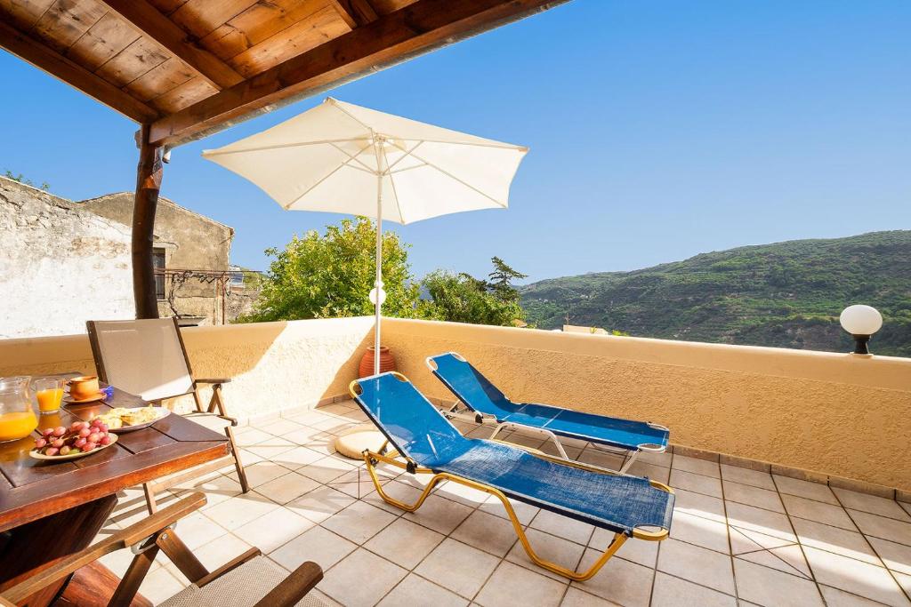 patio con tavolo, sedie e ombrellone di Topolia 1 Bedroom Villa a Topólia