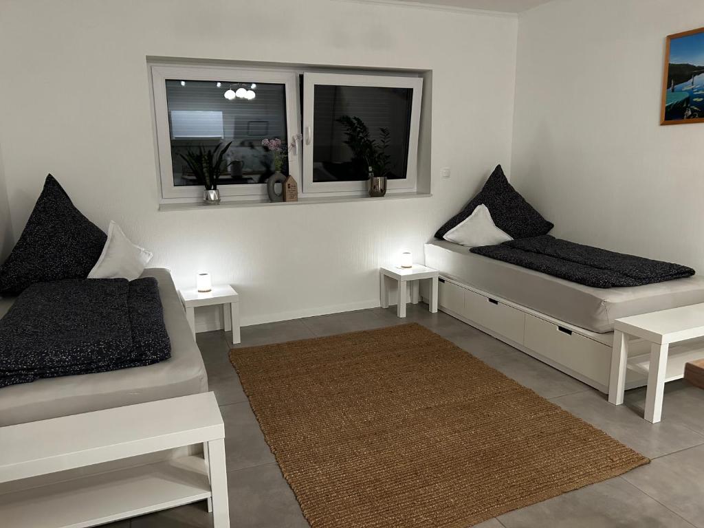 a white room with two beds and two windows at Apartment am Deister in Barsinghausen