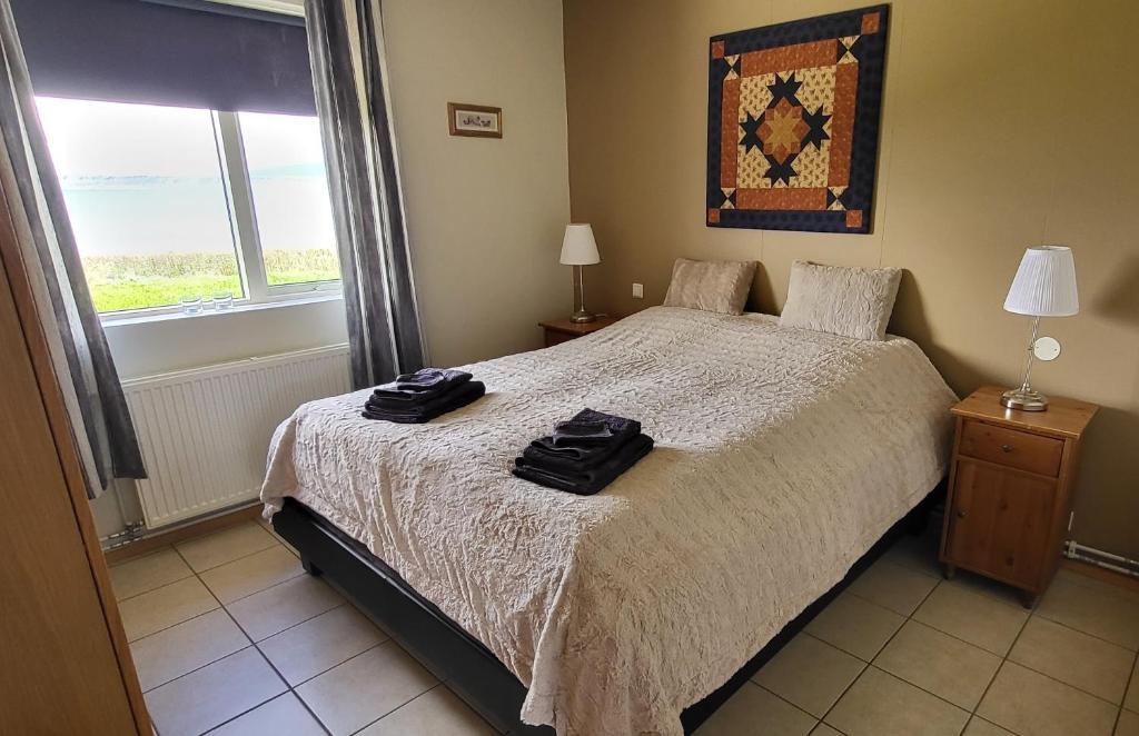1 dormitorio con 1 cama con 2 toallas negras en Kind guesthouse - the village en Búðardalur