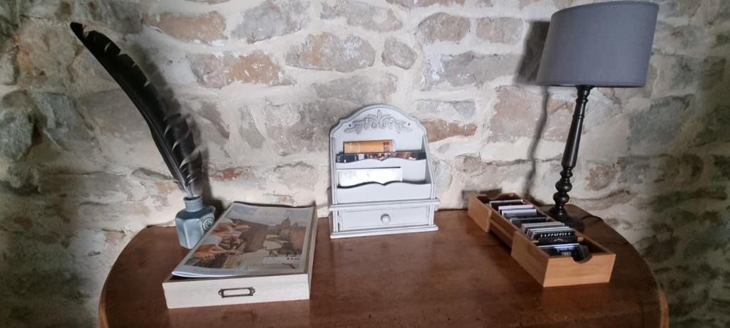 a table with a lamp next to a stone wall at Meublé de tourisme &quot;Les brosses tillots&quot; in Mary