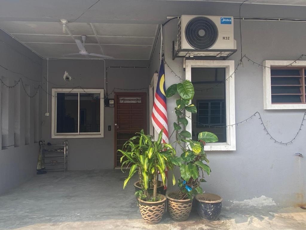 a house with an american flag and some plants at ANGGUN HOMESTAY Banting in Banting