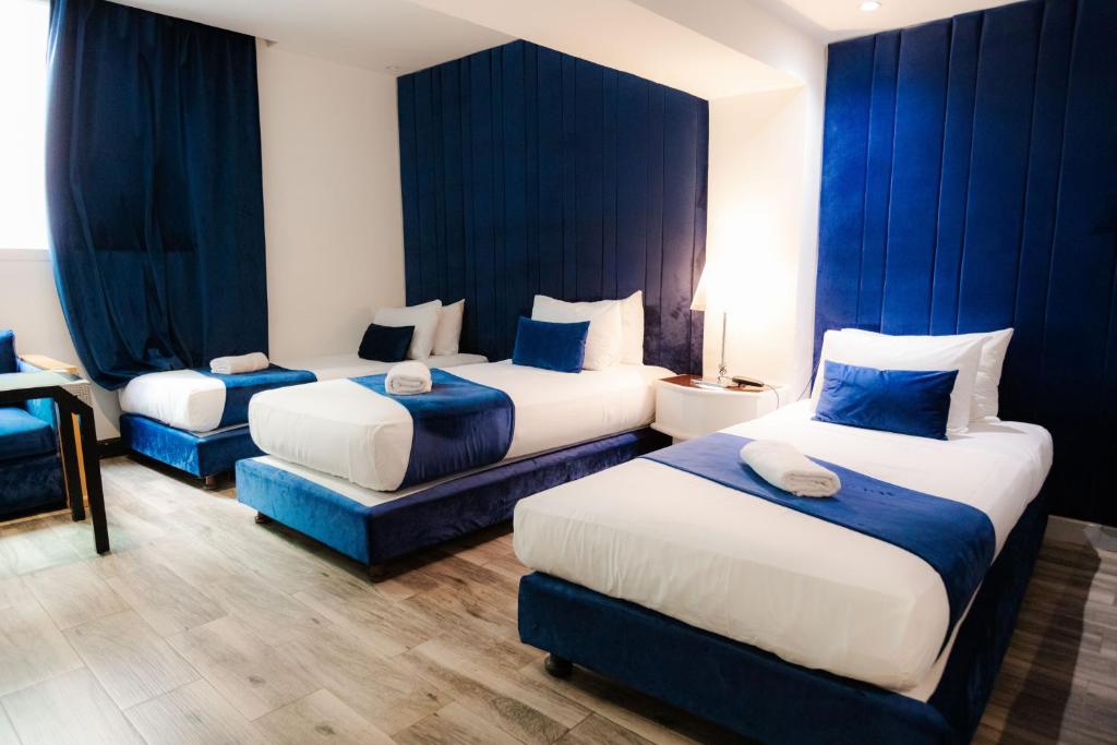 WINDSOR HOTEL CITY CENTER في الدار البيضاء: غرفة فندقية بسريرين مع ستائر زرقاء