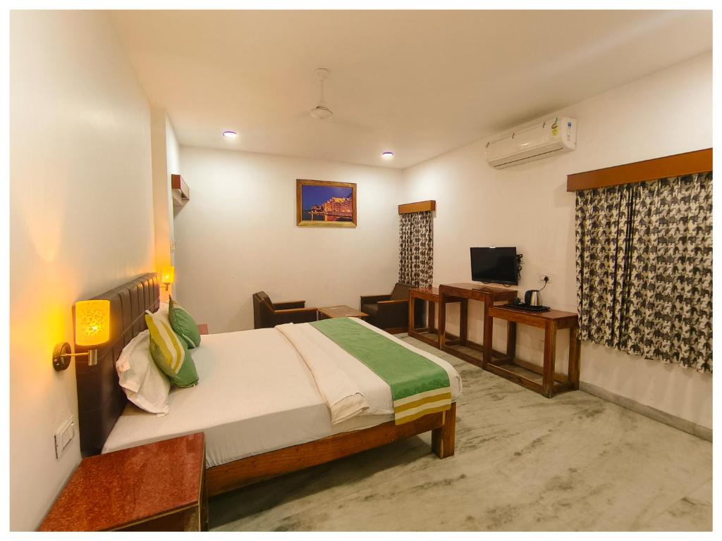 1 dormitorio con 1 cama y sala de estar en Hotel Rajshree Niwas, en Udaipur