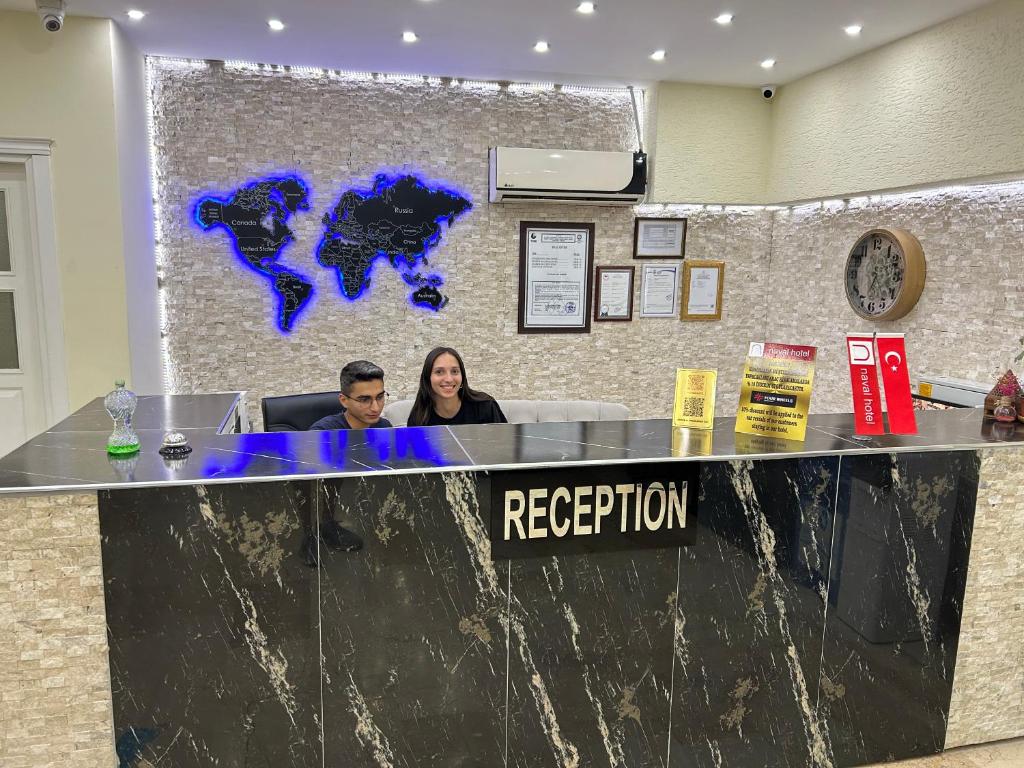 two people sitting at a reception desk in an office at NAVAL HOTEL YALOVA in Yalova