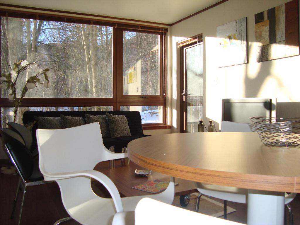 a living room with a table and white chairs at Depto Andes de Chillán in Nevados de Chillan