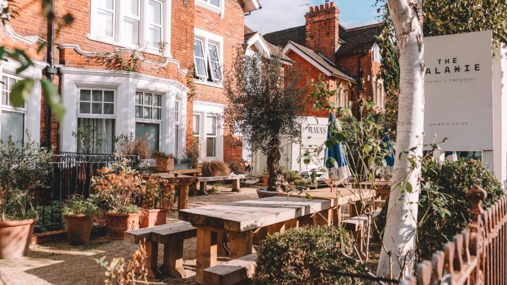 a garden with wooden benches in front of houses at The Galaxie in Oxford