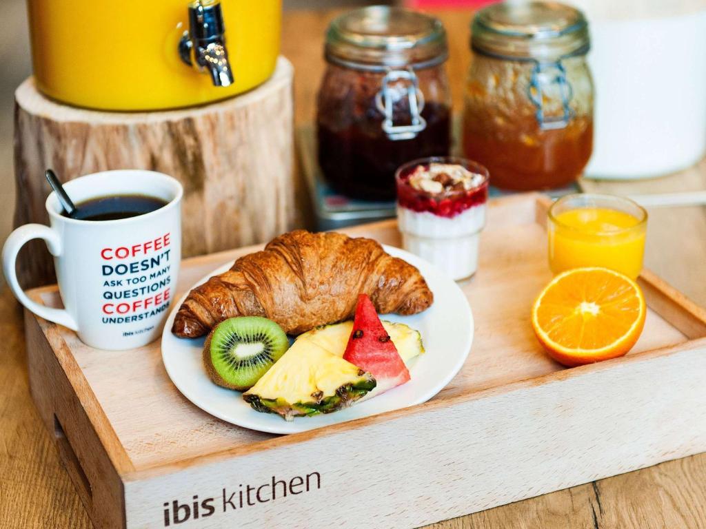 a plate with a croissant and fruit and a cup of coffee at Ibis Hong Kong Central & Sheung Wan in Hong Kong