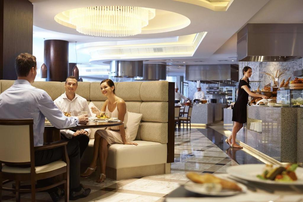 a group of people sitting at a table in a restaurant at Waldorf Astoria Dubai Palm Jumeirah in Dubai