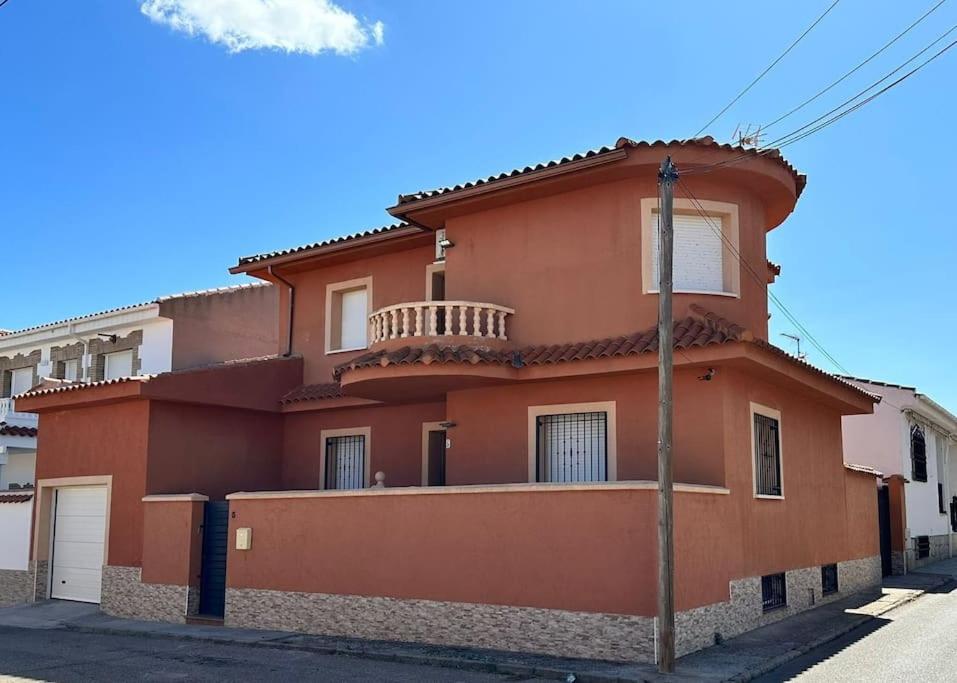 een oranje huis met een balkon in een straat bij El Nido VUT in Polán