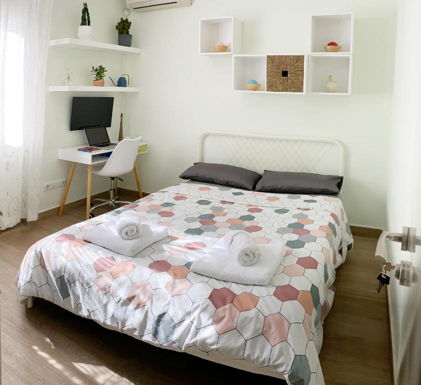 a bedroom with a bed with a desk and a computer at Cómoda Habitación Doble cerca de los lugares emblemáticos de Madrid in Madrid