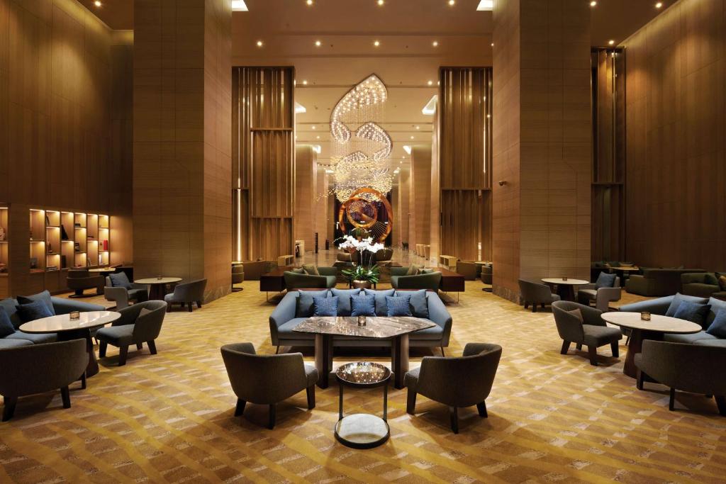 a lobby of a hotel with tables and chairs at Doubletree By Hilton Shah Alam I-City in Shah Alam