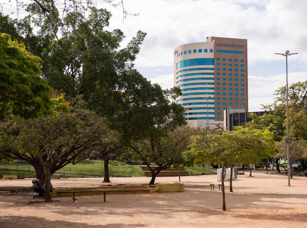 a park with trees and a tall building at Hilton Porto Alegre, Brazil in Porto Alegre