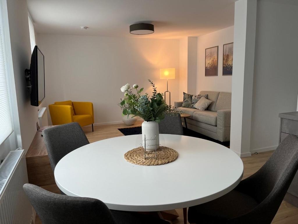 ein Wohnzimmer mit einem weißen Tisch und Stühlen in der Unterkunft Apartments Am Siebenborn in Eisenach