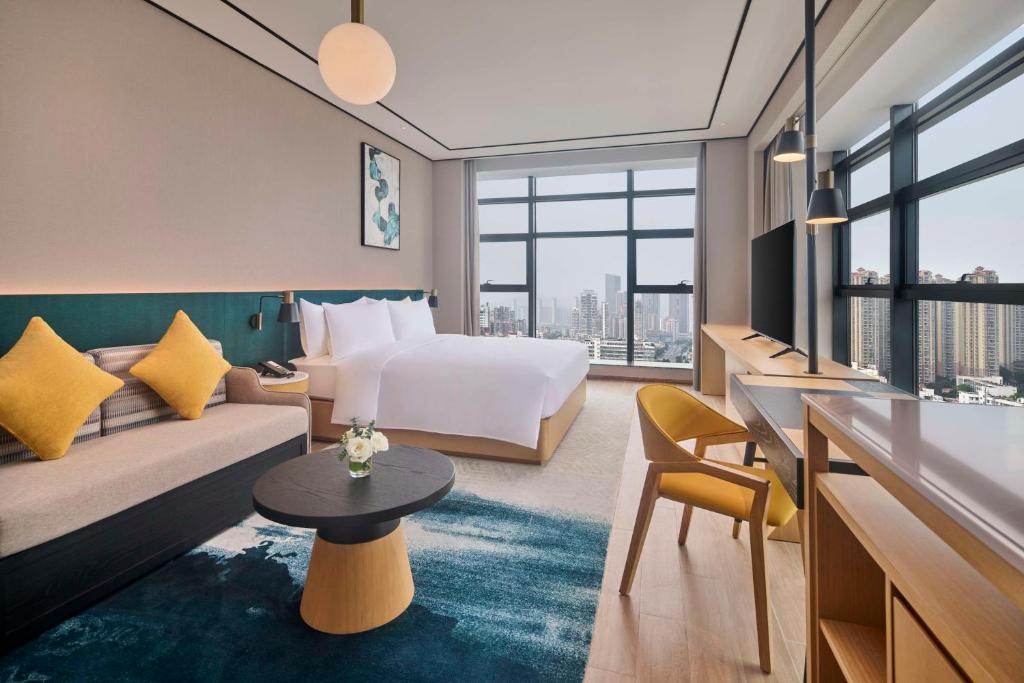 een hotelkamer met een bed en een bank bij Hilton Garden Inn Zhuhai Jinan University in Zhuhai