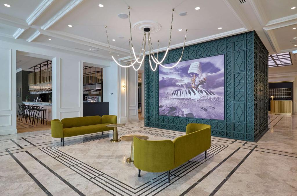 a lobby with two couches and a painting on the wall at Hotel Saski Krakow Curio Collection by Hilton in Kraków