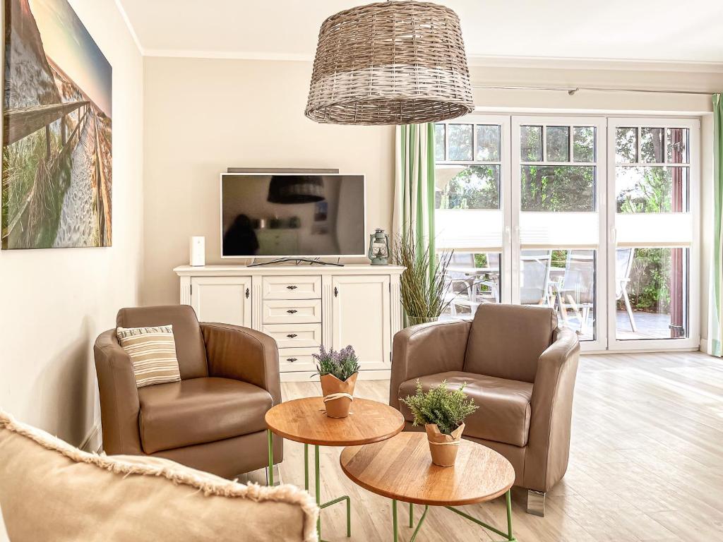 a living room with two chairs and a tv at Reethaus Am Mariannenweg 18b - Huus in Boltenhagen