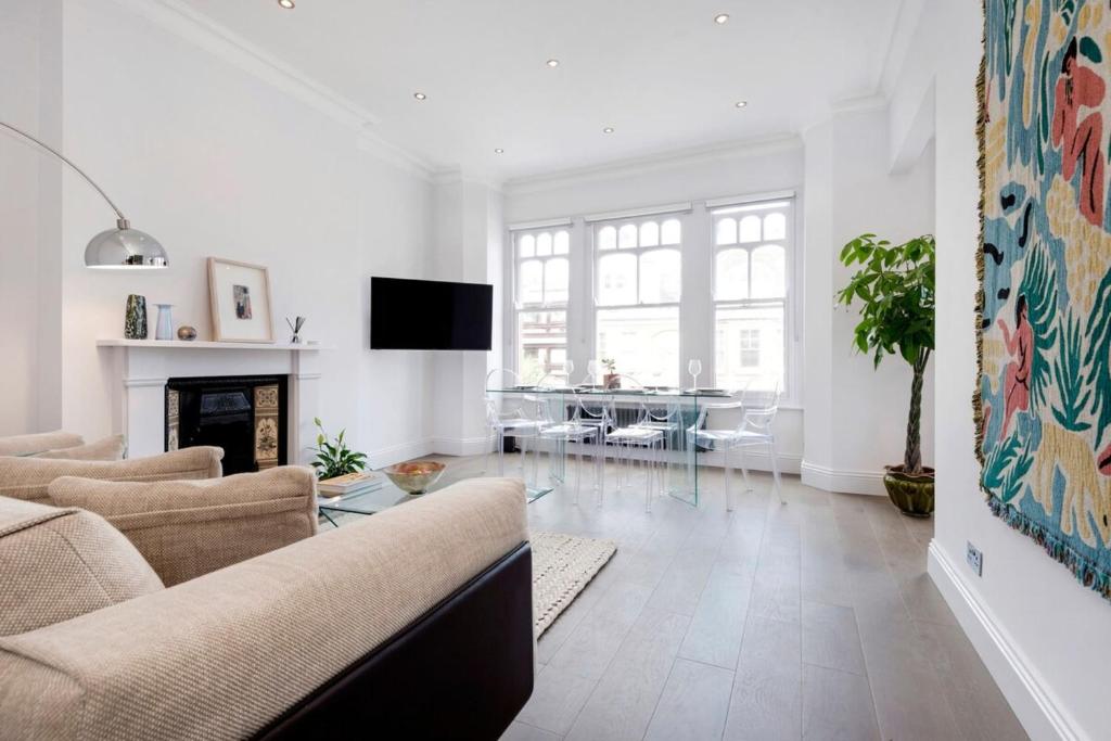 a living room with a couch and a fireplace at Modern and Bright Highgate Gem in London