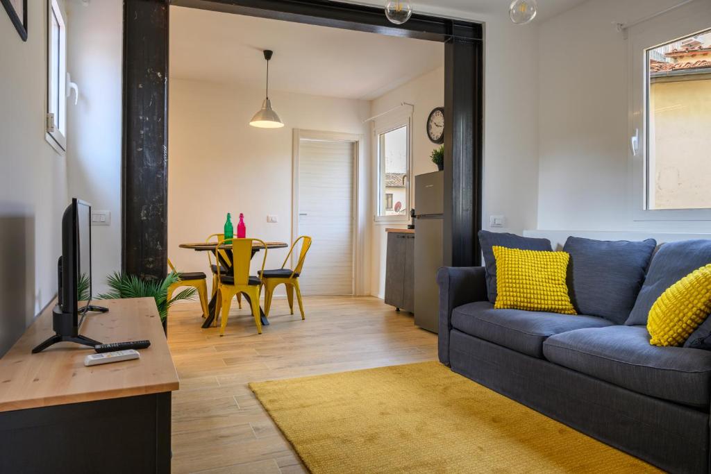 een woonkamer met een blauwe bank en een tafel bij Sapiti Modern by Mmega in Florence