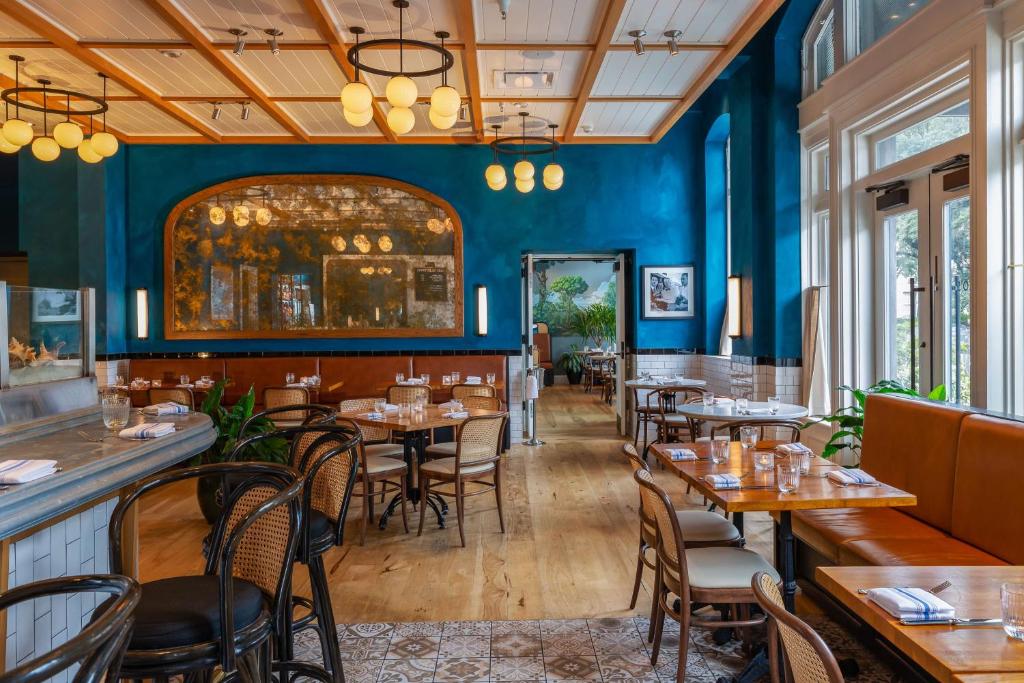 un ristorante con pareti blu e tavoli e sedie in legno di The Drayton Hotel Savannah, Curio Collection by Hilton a Savannah