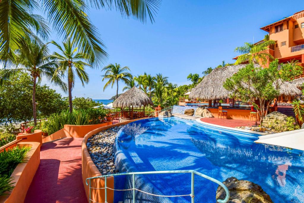 a resort with a swimming pool and a beach at Hilton Grand Vacations Club Zihuatanejo in Zihuatanejo