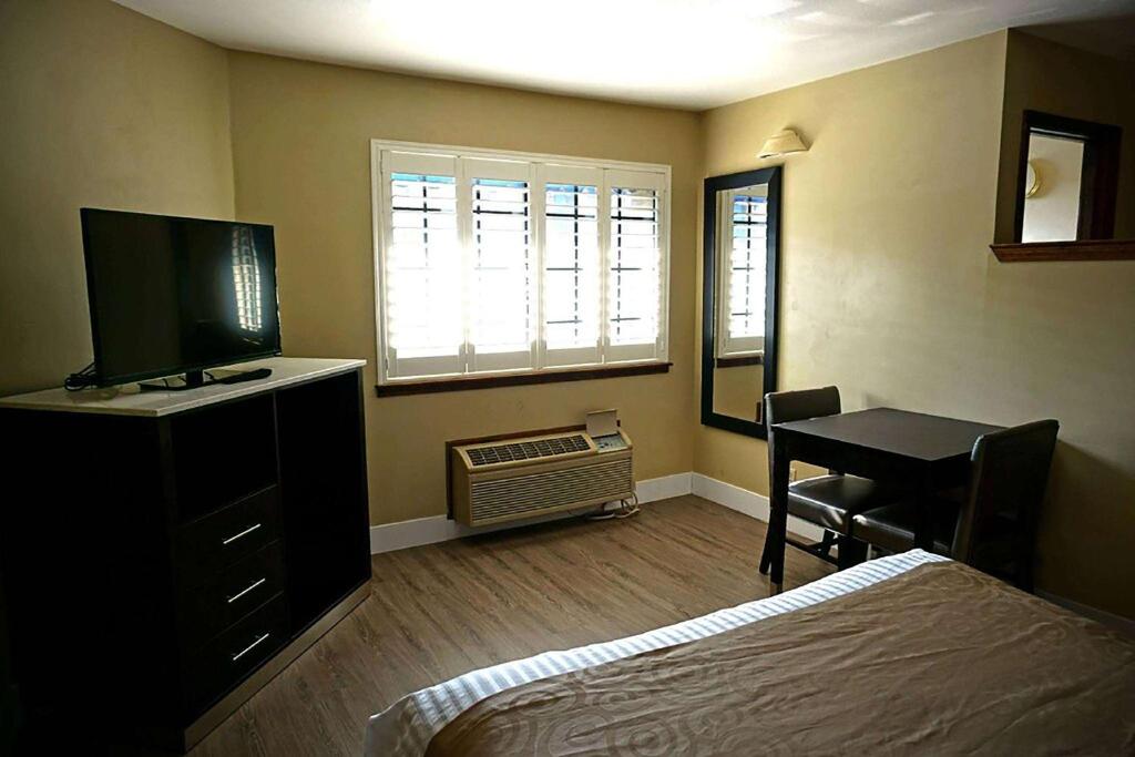 a bedroom with a bed and a desk with a computer at Travelodge by Wyndham Concord in Concord