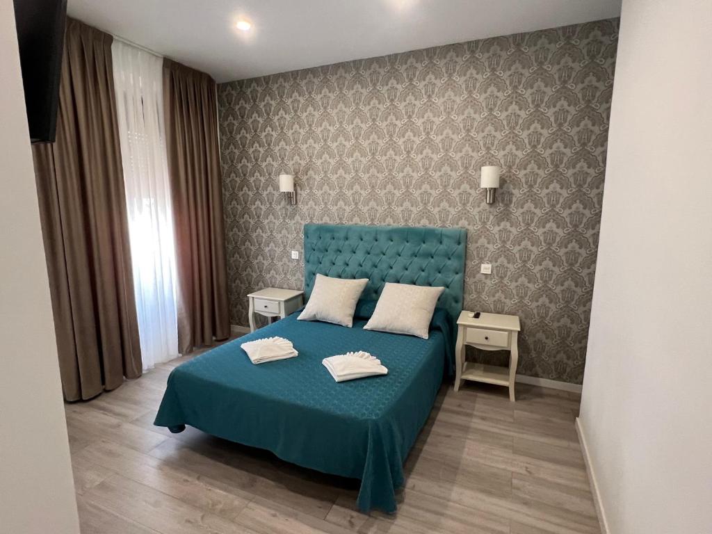 1 dormitorio con 1 cama azul y 2 almohadas en Hostal Galaico, en Madrid