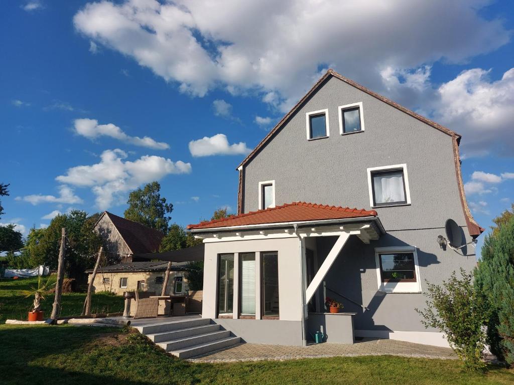 a gray house with a red roof at Haus am Seidelberg in Dürrhennersdorf