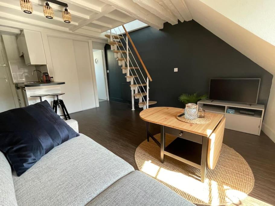 un salon avec un canapé et une table dans l'établissement Duplex - Chez Florian, à Fontainebleau